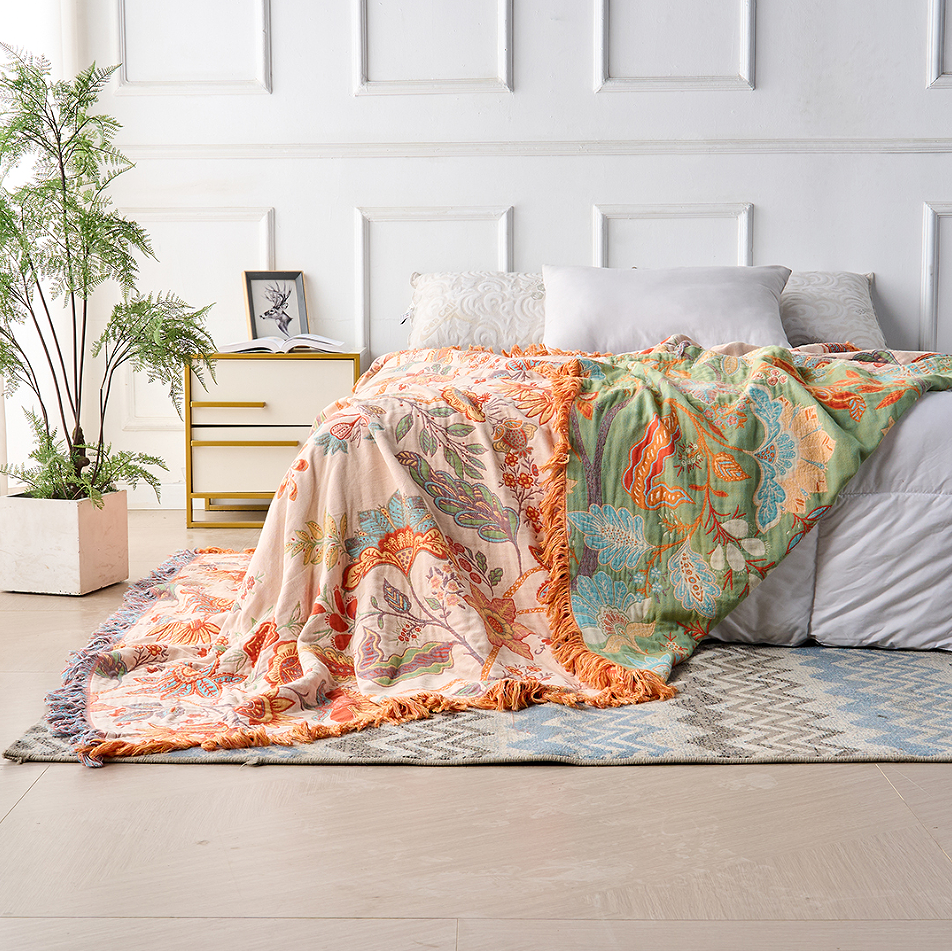 Cotton floral throw showing contrasting sides and tassels