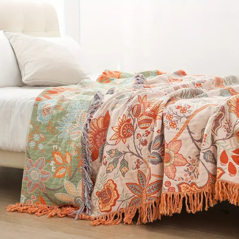 Close view of floral throw and tassel edging on a bed