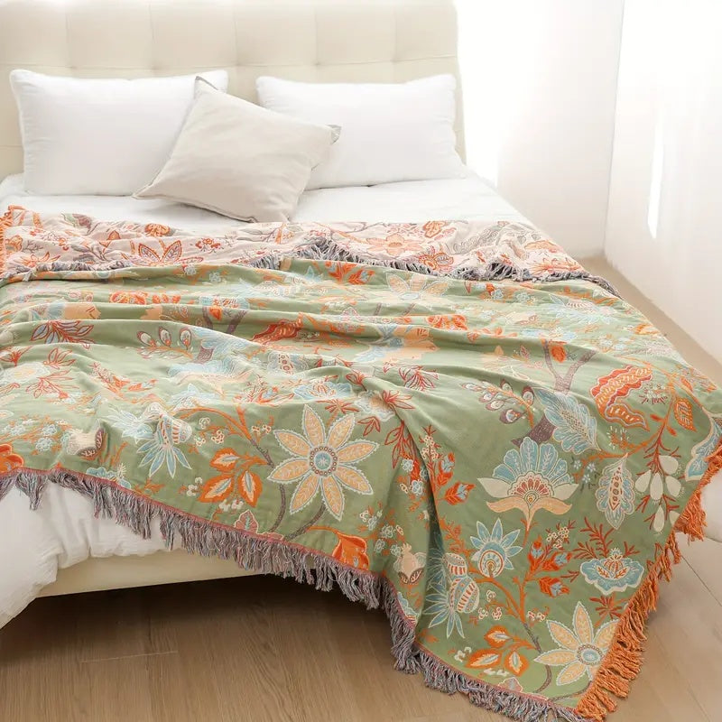 Green side of floral cotton throw spread over a bed