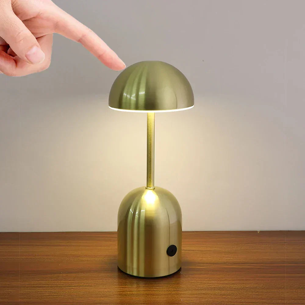 Gold table lamp being turned on by a hand with a finger