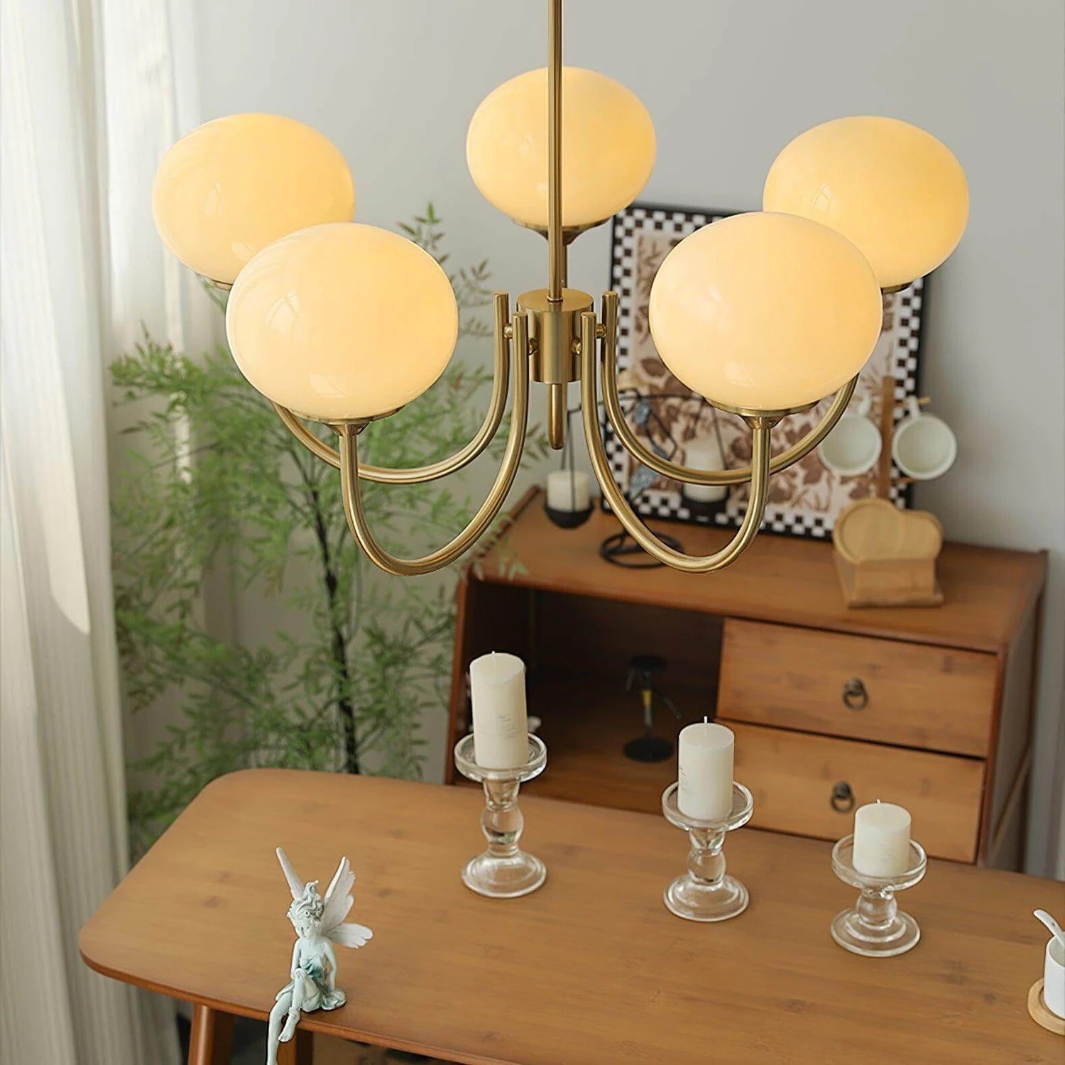 Modern glass ball pendant light with metal finish, suitable for living room or bedroom ceiling lighting.