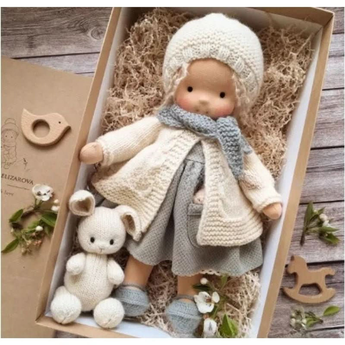 Blonde cloth doll in cream coat and blue scarf