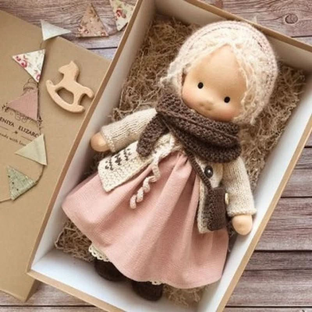 Blonde cloth doll in pink dress and brown scarf