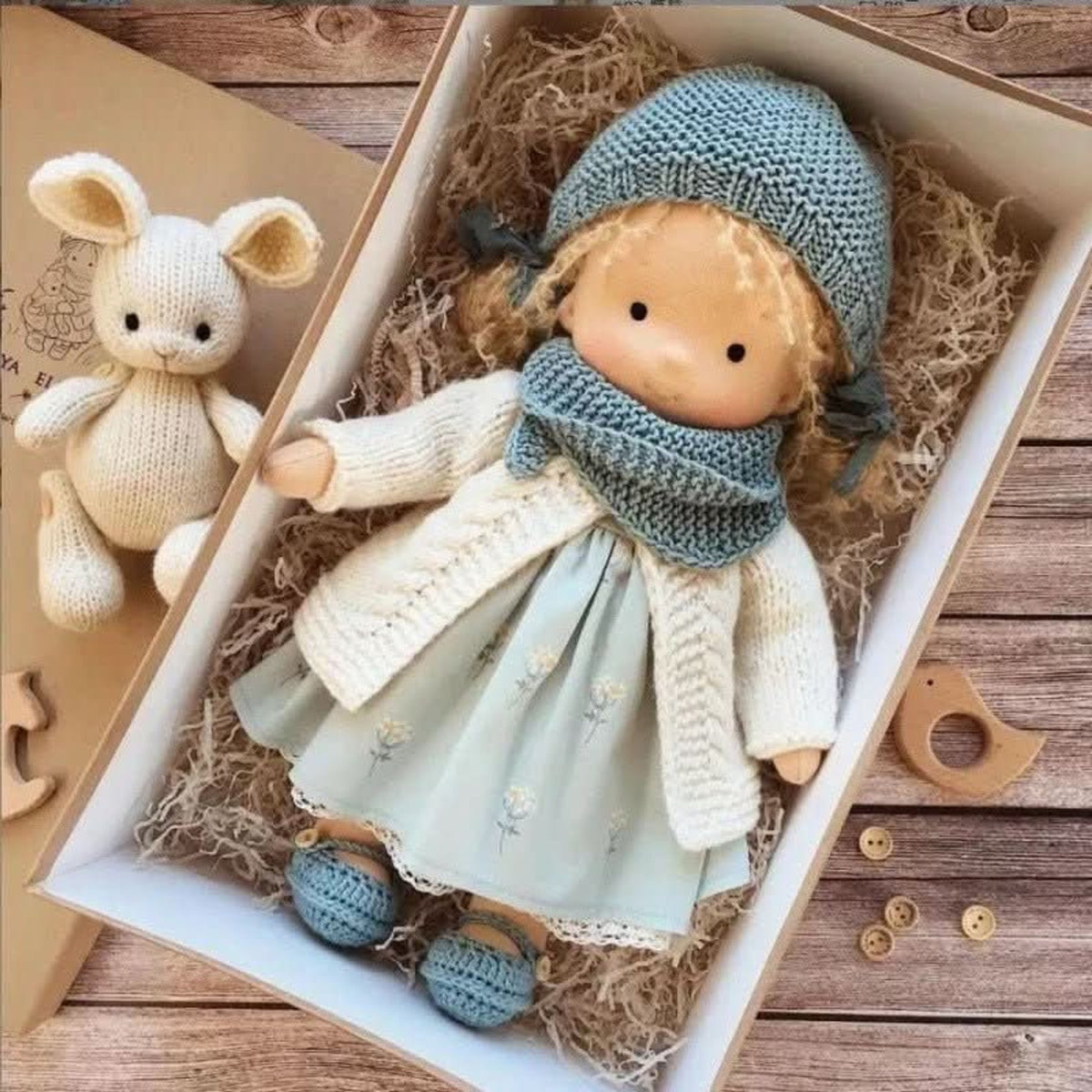Blonde cloth doll in blue floral dress and cream cardigan