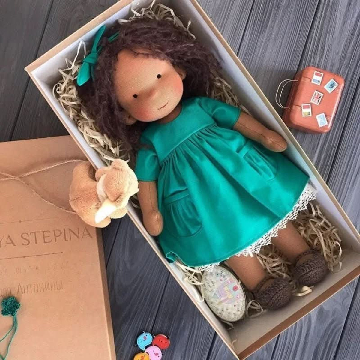 Brown-skinned cloth doll in teal dress with matching bow