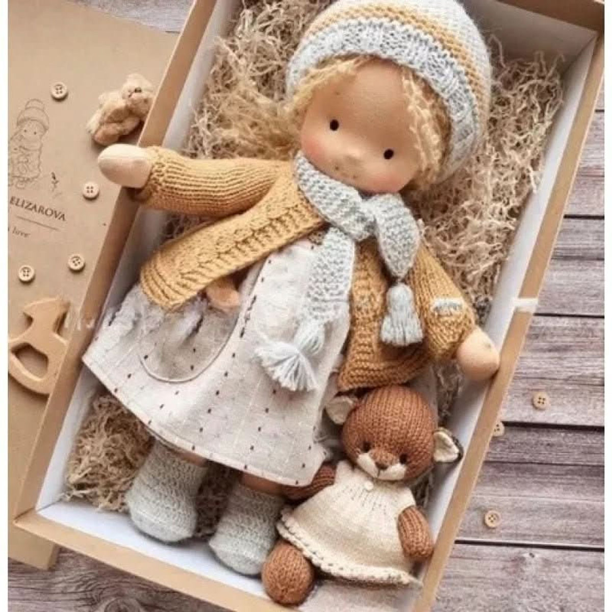 Blonde cloth doll in ochre cardigan and blue hat