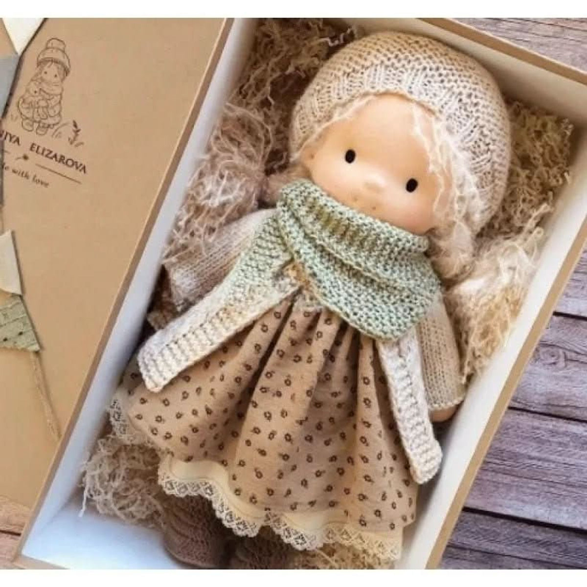 Blonde cloth doll in brown patterned dress and green scarf