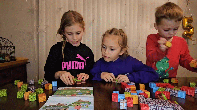 Children assembling magnetic cube buildings