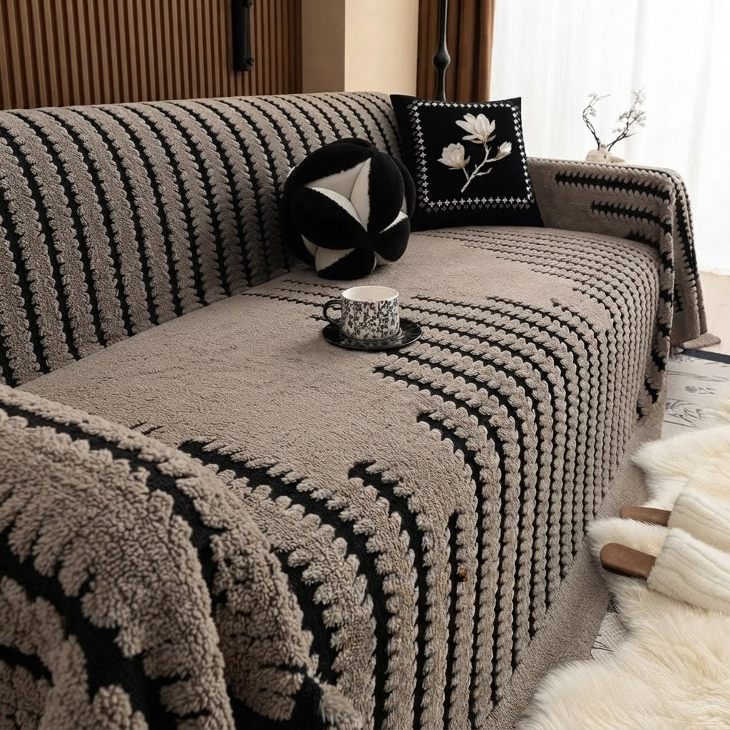 Taupe tufted blanket with contrasting black stripes covering a sofa