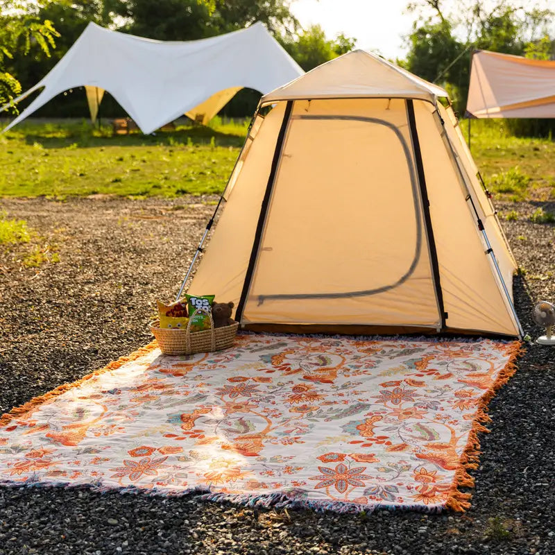 Floral cotton throw spread outside a tent
