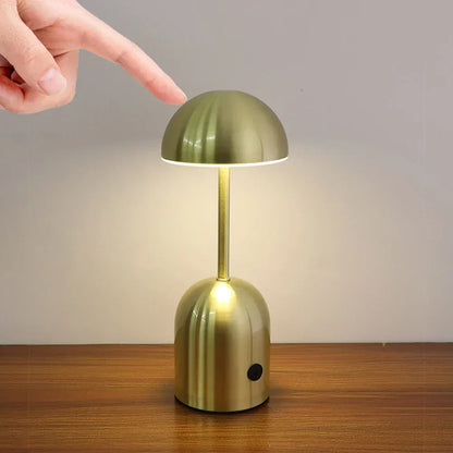 Gold table lamp being turned on by a hand with a finger
