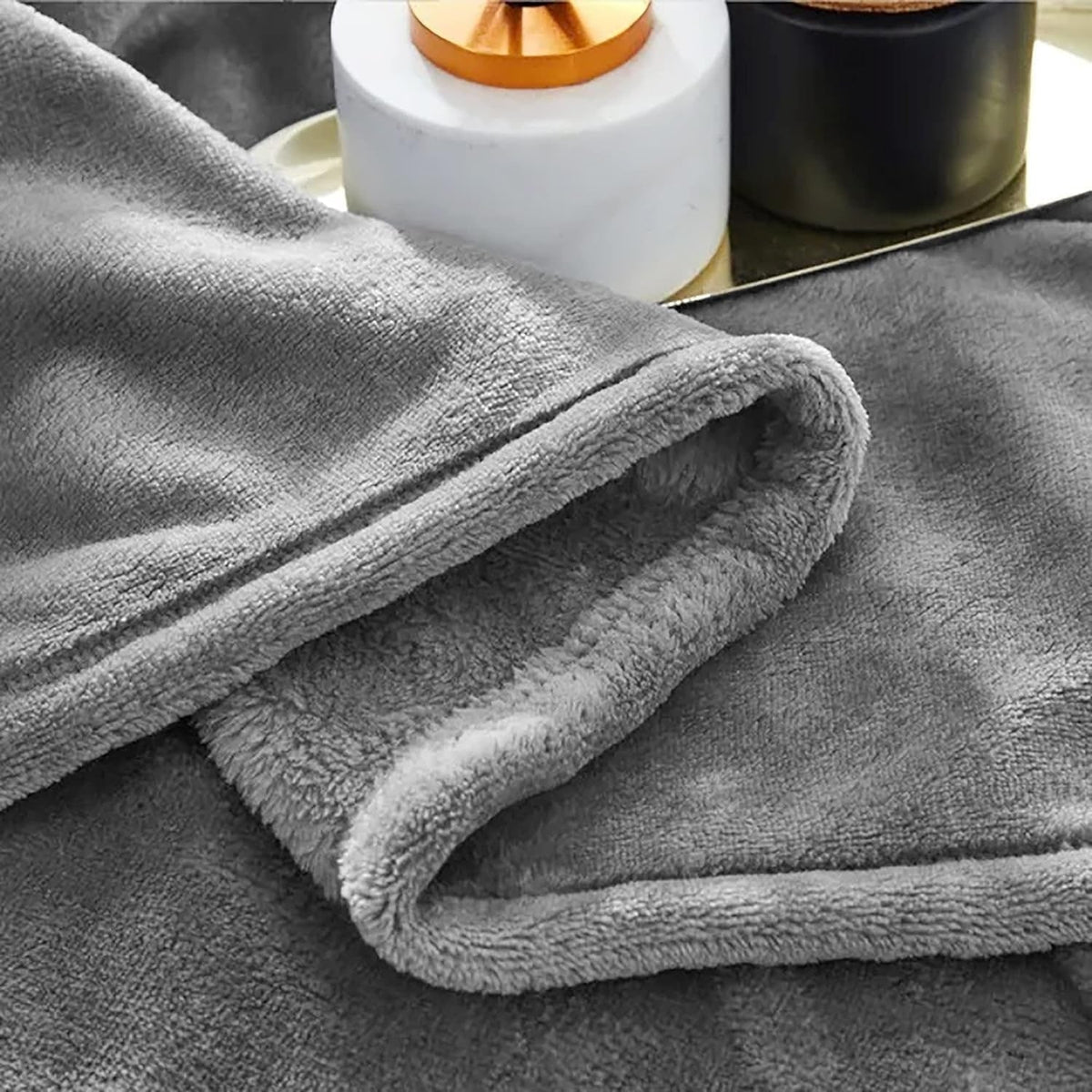 Grey fleece blanket showing short pile and stitched hem