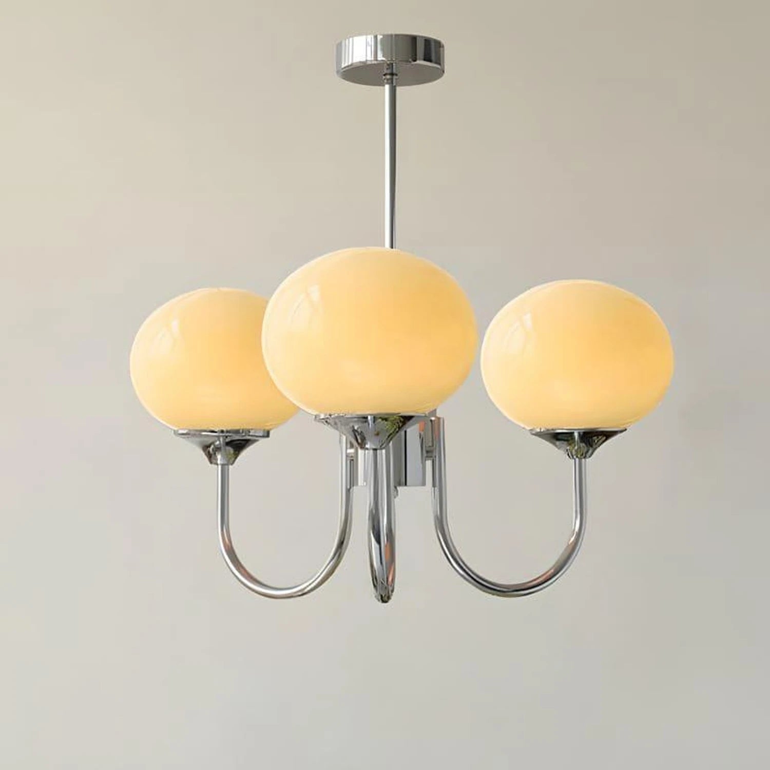 Modern glass ball pendant light with metal finish, suitable for living room or bedroom ceiling lighting.