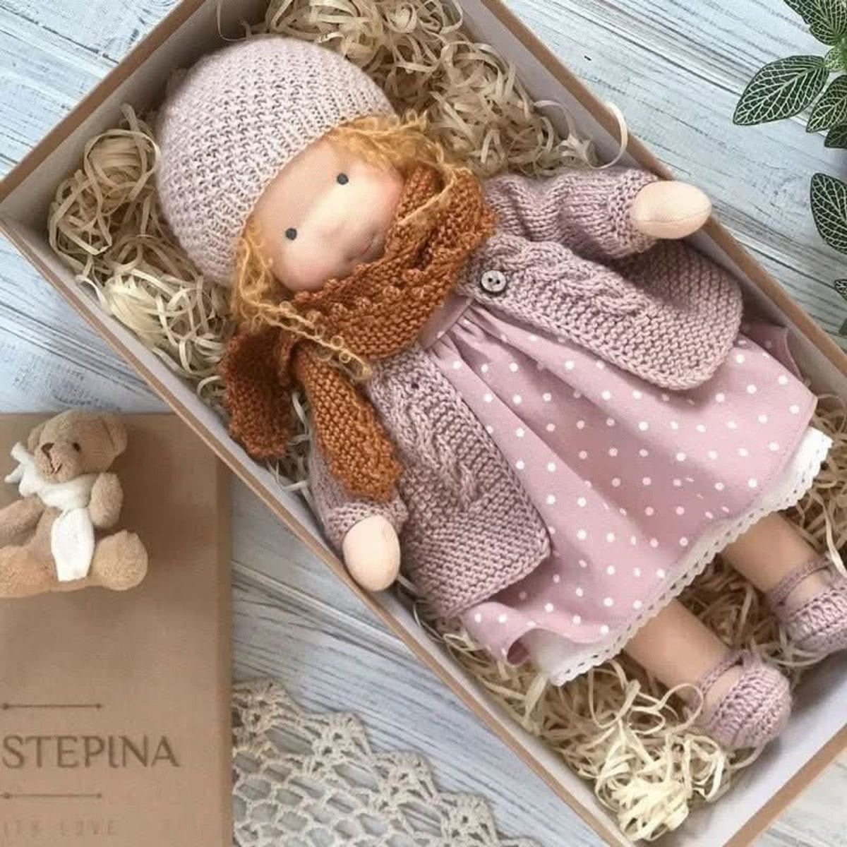 Red-haired cloth doll in pink polka-dot dress and coat