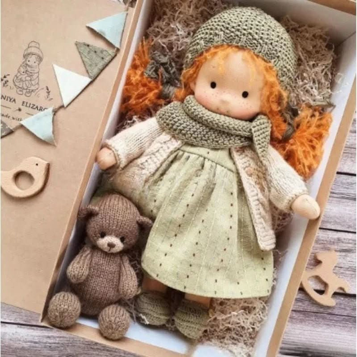 Red-braided cloth doll in green-grey hat and scarf