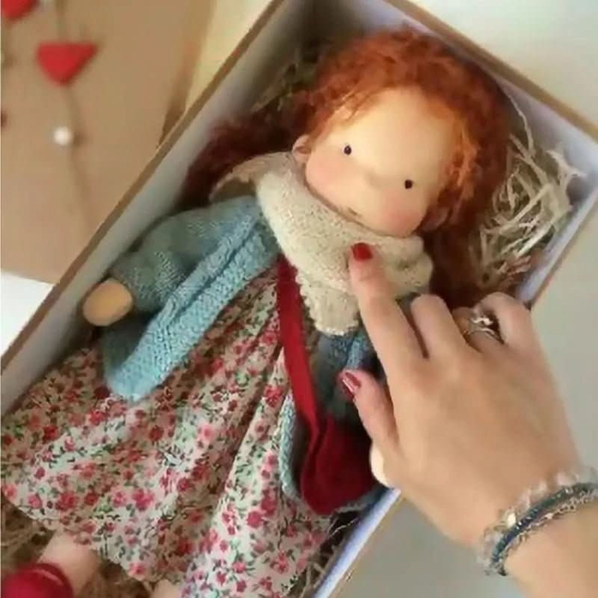 Red-haired cloth doll in turquoise cardigan and red bag