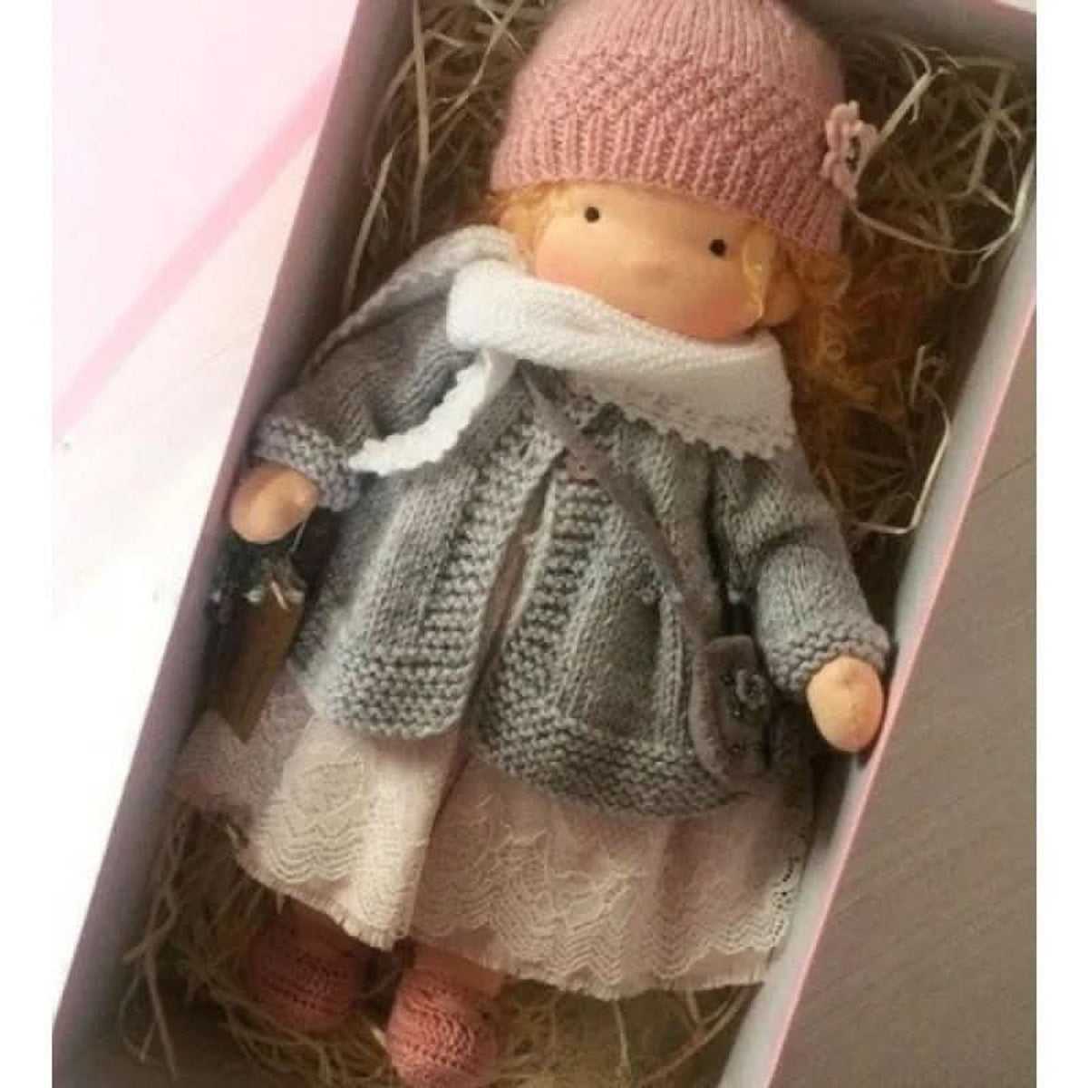 Blonde cloth doll in pink hat and grey cardigan