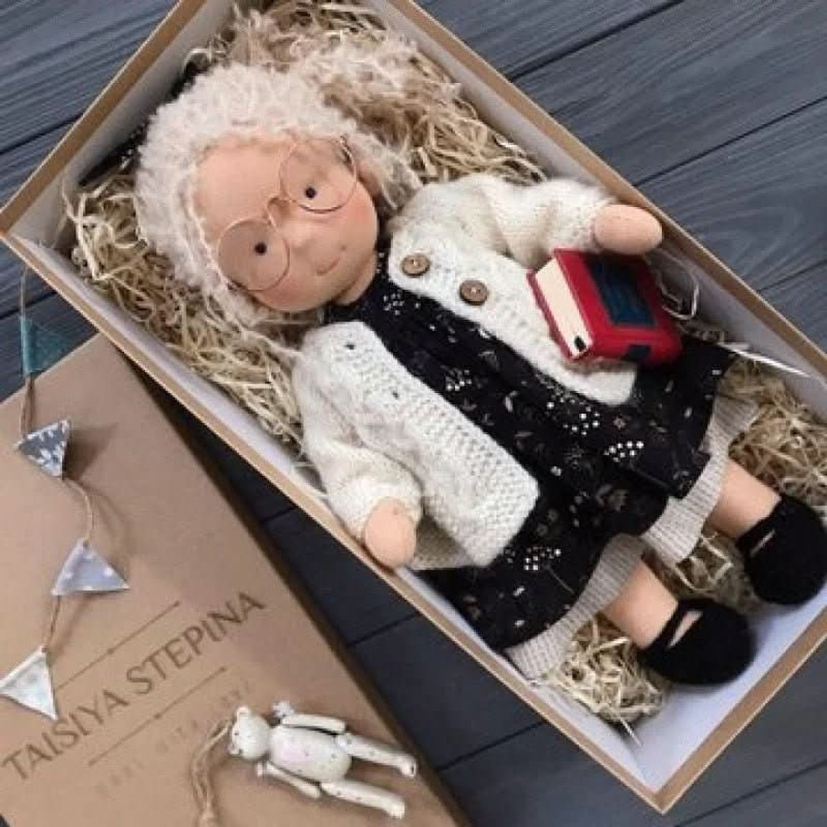 Grey-haired cloth doll with glasses and cream coat