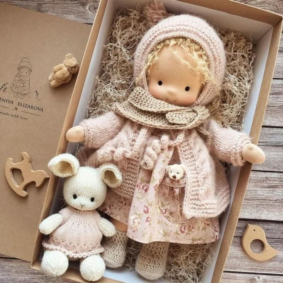 Blonde cloth doll in pink floral dress and pink coat
