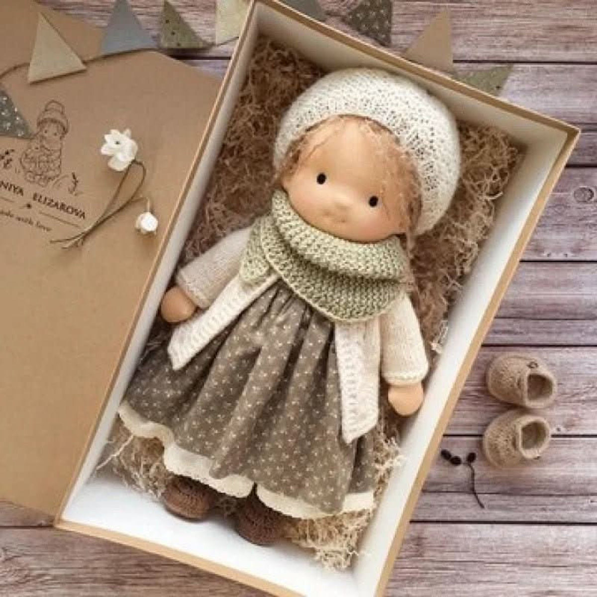 Blonde cloth doll in cream bonnet and green scarf