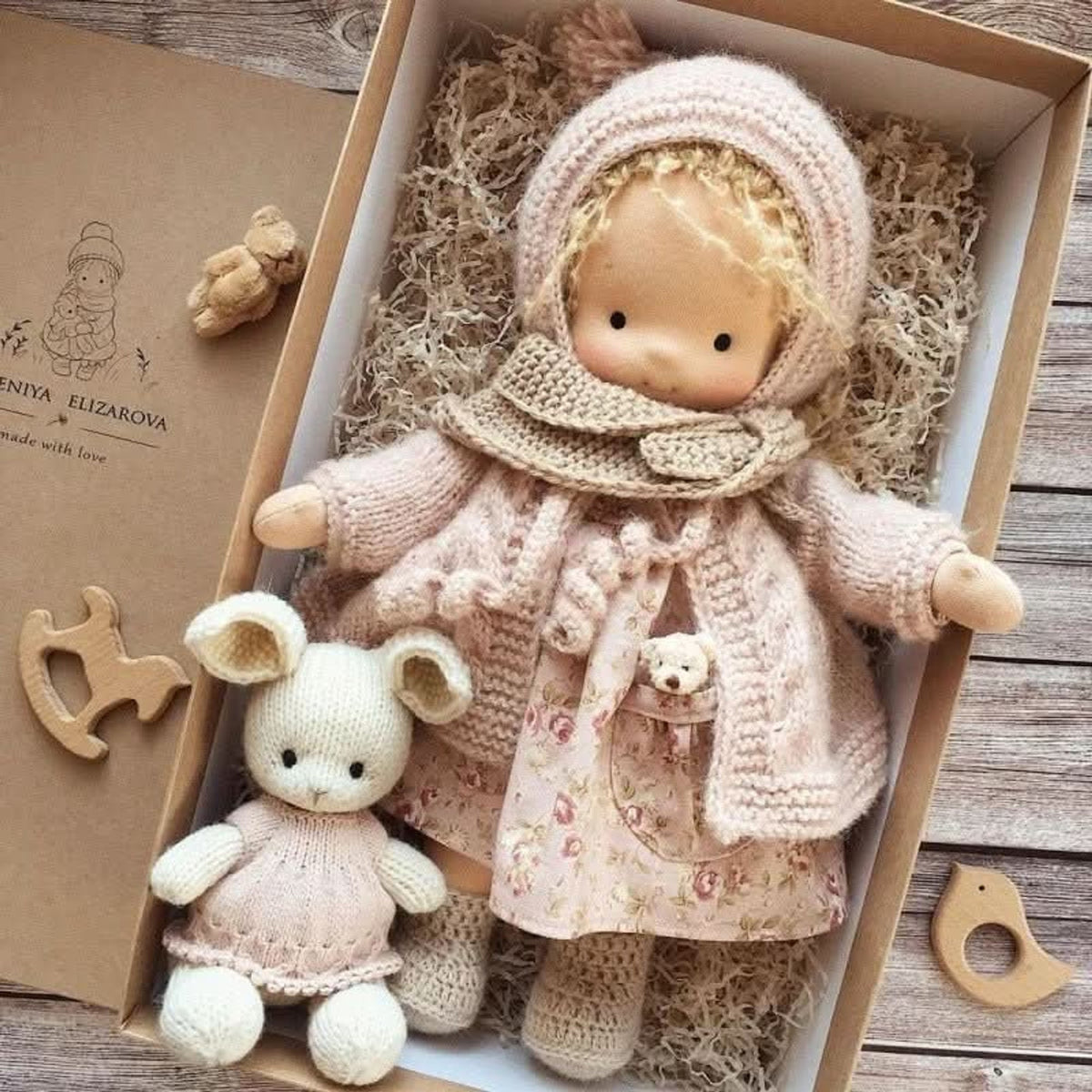 Blonde cloth doll in pink floral dress and pink coat