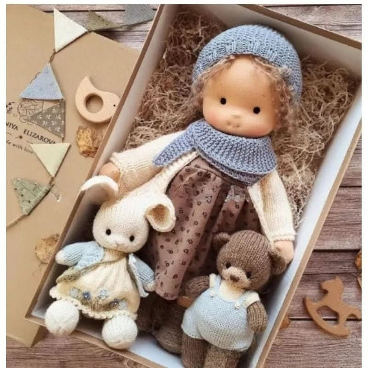 Blonde cloth doll in blue hat and scarf with cream coat